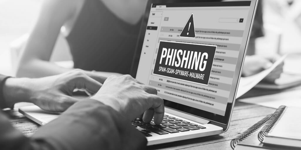 A computer screen shows a cybersecurity alert warning of a cyber attack. The alert highlights dangers from viruses, phishing, and cyber fraud, emphasizing the importance of protection against these threats. The background features various security-related icons and symbols.