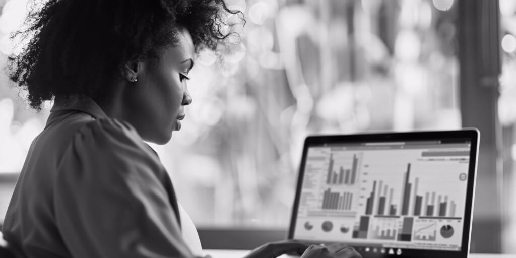 A person looking at a laptop screen displaying various financial graphs and charts