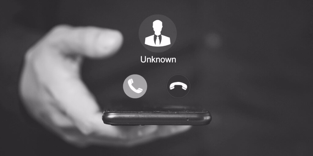 Person holding a smartphone showing an incoming call from an unknown number